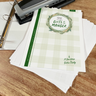 Stack of 'Gifts in the Manger' booklets on a wooden surface with stationery items.