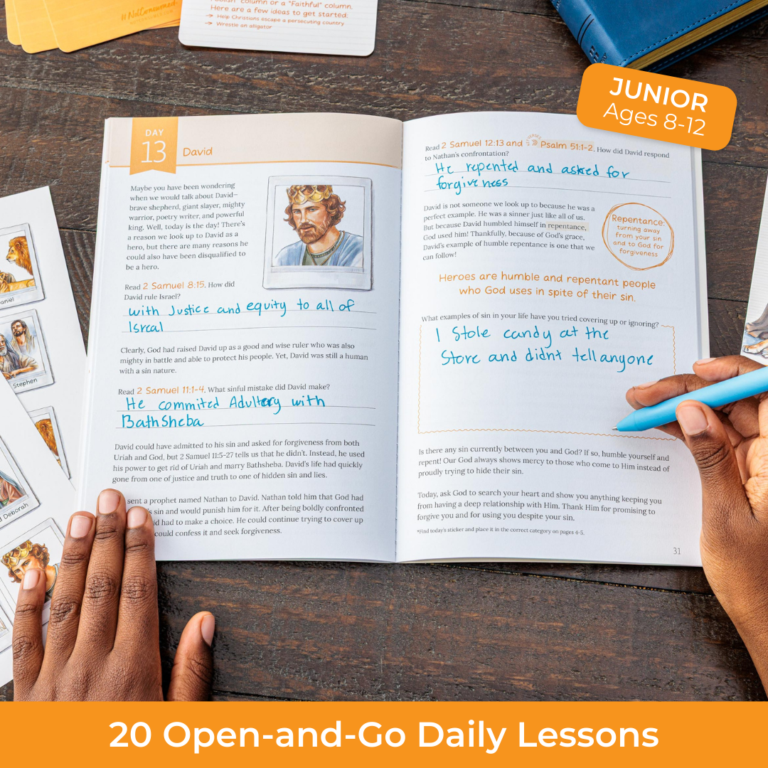 Open book with educational content on a wooden surface, surrounded by cards and a pen.