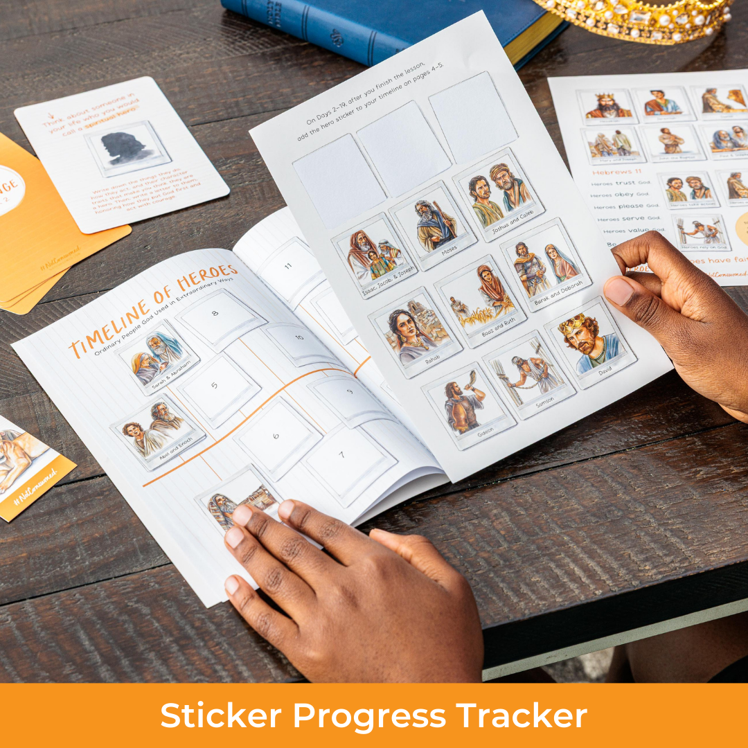 Person using a sticker progress tracker book on a wooden table with cards and books around.